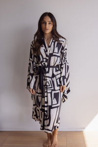 Woman wearing a black and cream robe. Made from silky-soft, breathable bamboo robe. With a tie waist for an adjustable fit, hidden pockets and wide sleeves. Perfect for lounging.